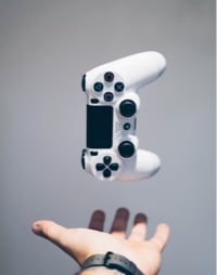 A hand throwing a white gaming controller into the air